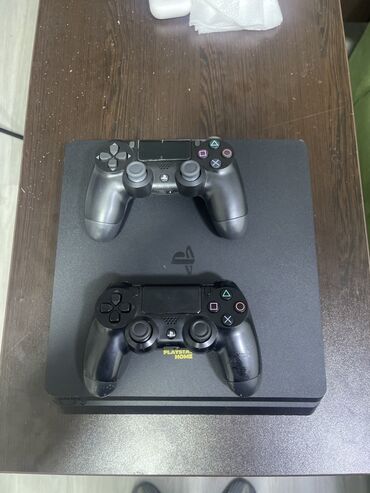 ucuz playstation 4 oyunları: Qara rəngdə olan PlayStation 4 oyun konsolu, iki ədəd Dualshock 4 oyun