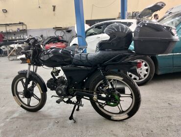 maped: Tam qara rəngdə, yığcam dizayna malik motosiklet. Bu motosiklet iki