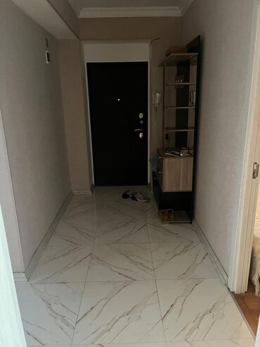 qapi tutacaqlari: Qara rəngdə giriş qapısı, qonaqları qarşılamağa hazırdır. Mərmər