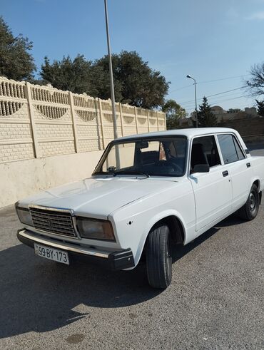 Ağ rəngli dördqapılı Lada avtomobili. Avtomobilin qabaq hissəsində