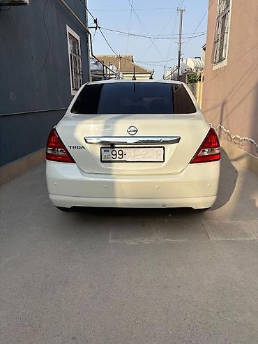nisan note: Ağ rəngli Nissan Tiida sedan. Avtomobilin salonu açıq bej tonlarda — 10