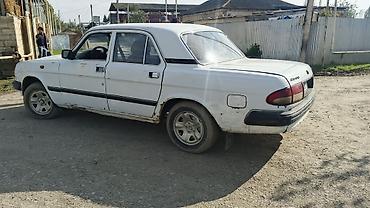 2 qapılı maşın: Ağ rəngli GAZ 3110 sedan avtomobil. Klassik kuzov quruluşuna malik 4 — 4