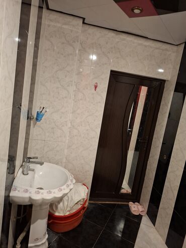 Unitazlar: Ağ və qara rənglərdə keramik plitələrlə döşənmiş müasir hamam. Hamam — 1