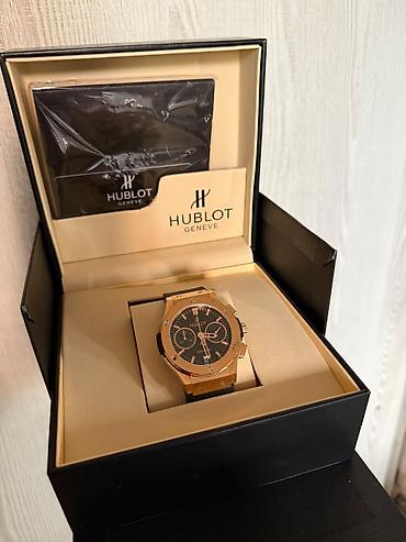 saat samdan: Hublot Geneve qol saatı - Korpus: qızılı tonlu metal, qabaqda markaya — 1