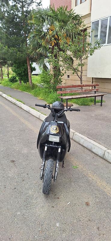 skuter toba: Qara rəngli şəhər skuteridir. Kompakt kuzov, enli ön təkər və ikili ön — 1