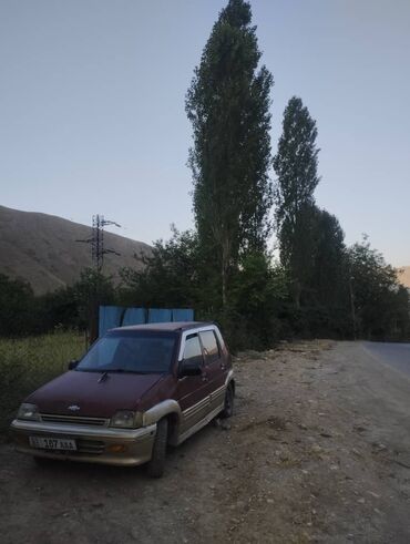 красные машины: Хэтчбек Daewoo Tico в бордовом цвете, оснащенный багажником на крыше