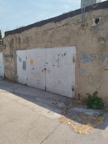 Kirayə qaraj: Beton divarlı və metal qapılı qaraj. Divarlarında müxtəlif qraffiti və