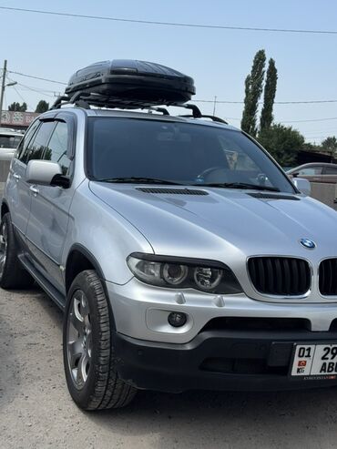 руль для скутера: Серебристый внедорожник BMW X5, оснащенный черным багажным боксом на