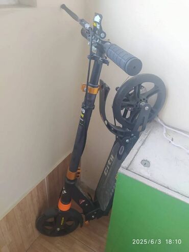 orfoqrafiya ve orfoepiya lugeti: Qara və narıncı rənglərdə olan "City Riding" markalı skuter
