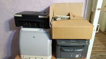 Şəkildə bir neçə printer təsvir olunub. Onlardan biri HP markalı qara