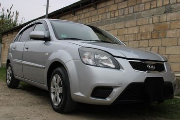 Kia: Kia Rio hatchback – gümüşü rəngdə, 5 qapılı şəhər avtomobili. Xarici — 4