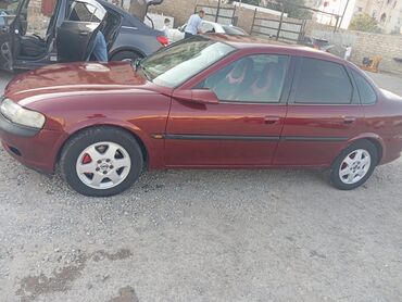 Tünd qırmızı rəngdə Opel Vectra sedan avtomobili. Avtomobilin