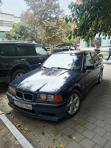 BMW: BMW E36 sedan kuzalı avtomobil. Tünd göy rəngdədir və klassik BMW — 7