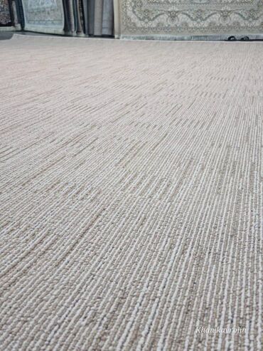 isdenmis xalca: Minimalist dizayna malik bej rəngli xalça/kovrolin. Səthin strukturu