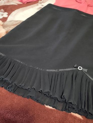 Crna suknja do kolena sa plisiranim porubom u dva sloja. Asimetričan