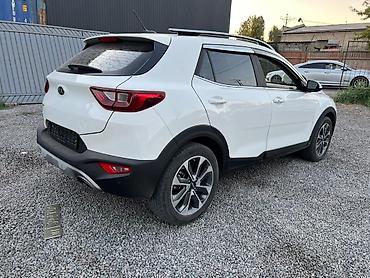 Kia: Компактный кроссовер Kia Stonic белого цвета, оснащенный рейлингами на — 3
