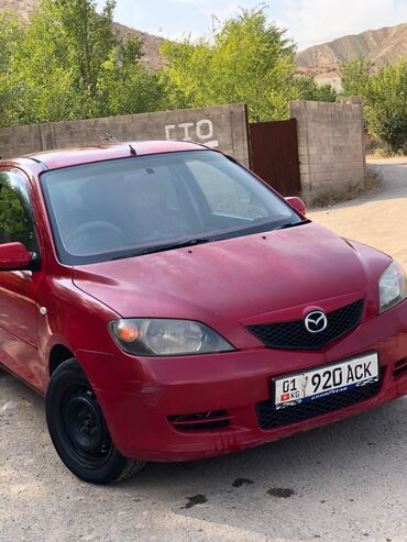 шины оптом: Красный хэтчбек Mazda Demio с черной решеткой радиатора и эмблемой