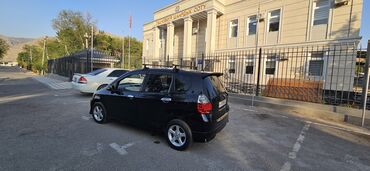 кроссовер машина купить: Черный минивэн Honda Fit с рейлингами на крыше и спойлером. Автомобиль