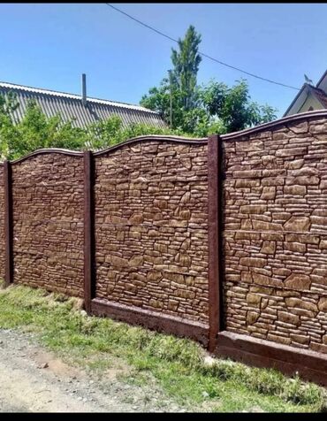 апалубка продаю: Декоративный забор, выполненный из бетонных секций, имитирующих