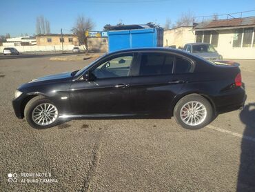 обмен на малолетражку: Черный седан BMW 3 серии, оснащенный литыми дисками и красными