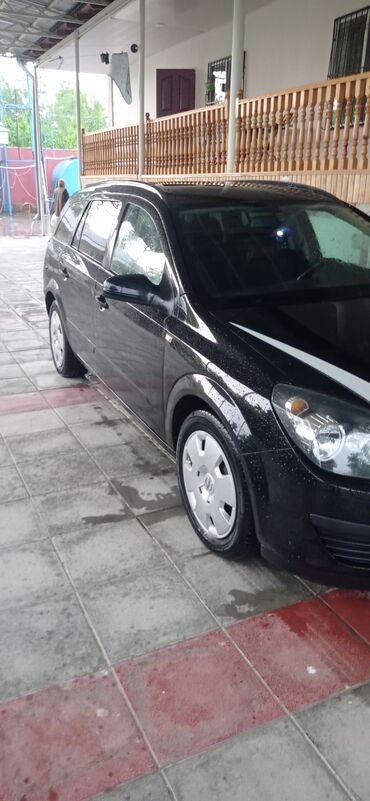 Opel: Qara rəngdə olan Opel Astra universal avtomobili. Avtomobilin ön — 3