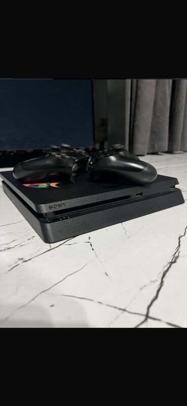 PS4 (Sony Playstation 4): Qara rəngdə olan Sony PlayStation 4 Slim 1TB oyun konsolu. Kompakt