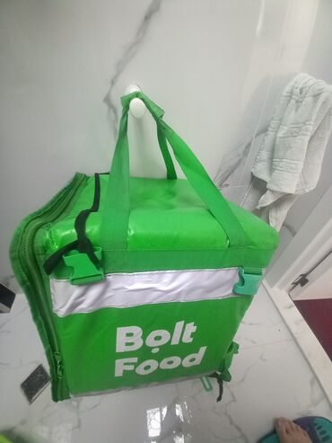 Popkorn aparatları: Bolt Food loqosu olan yaşıl rəngli çatdırılma çantası. Bu çanta