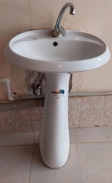 Mətbəx kranları: Ayaqlı keramik lavabo, ağ rəngdədir və tək dəlikli mikser üçün nəzərdə