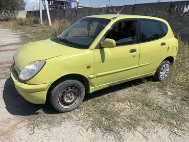 машина сатуу: Субкомпактный автомобиль Daihatsu Storia ярко-салатового цвета. Этот