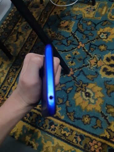 переходник для наушников и микрофона для ноутбука: Смартфон синего цвета с разъёмом 3,5 мм для наушников. На задней