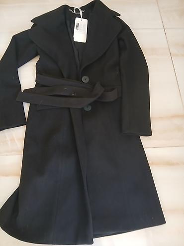 Elegantni ženski kaput, crne boje, klasičnog kroja do kolena. Model sa