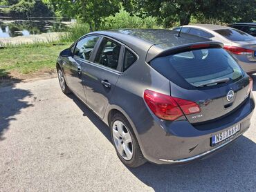 naslon za glavu za auto: Opel Astra J hečbek u sivoj boji, sa petoro vrata. Vozilo je