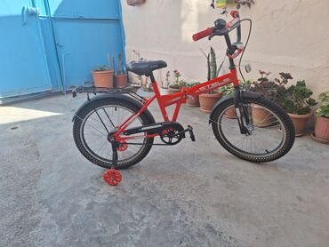 Qırmızı rəngdə, qatlanan çərçivəyə malik uşaq velosipedi. Bu velosiped