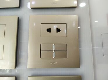 smart açar: MODI markalı, qızılı rəngdə elektrik rozetkası və açarı. Evdə və ya