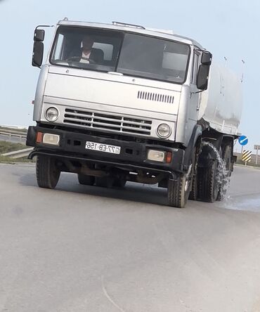 Yük maşınları: Gümüşü rəngli KAMAZ markalı yük maşını, arxasında böyük, ağ rəngli çən