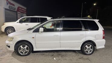 7 местный машина: Универсал Mitsubishi белого цвета, оснащенный рейлингами на крыше для