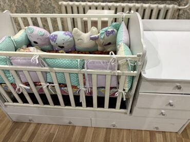 детский кийим салгыч: Белая детская кроватка с комодом и ящиками для хранения. Изготовлена
