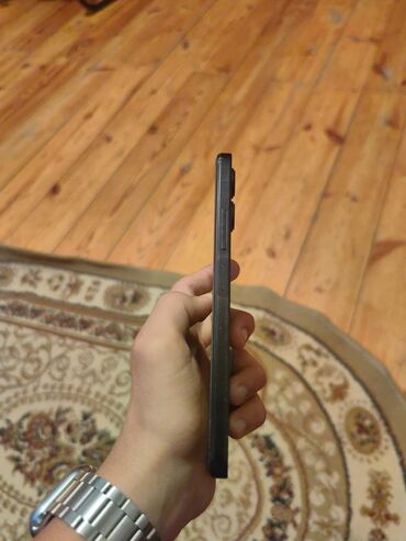 inci su: Smartfon – qara rəngdə, düz kənarlı korpus, ön hissədə mərkəzdə