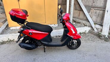 moped sumqayıt: Arxa hissəsində üst çamadanı olan qırmızı rəngli Zigzag skuter. Bu