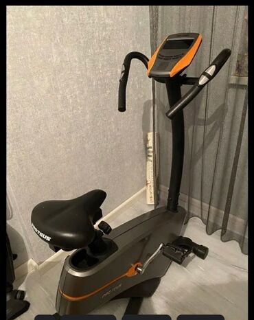 Elliptik trenajorlar: Pro-Form idman velosipedinin qara oturacağı və narıncı ekranı var. Bu