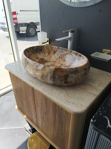 canaq: Mərmər naxışlı, oval formalı əl-üz yumaq üçün lavabo. Dolabın üstünə