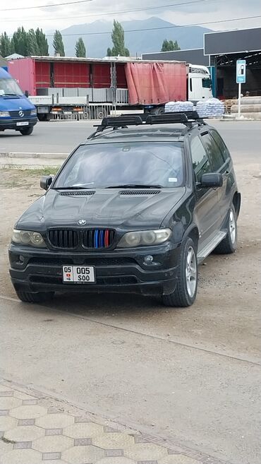 продаю х5: Черный внедорожник BMW X5, оснащенный багажником на крыше для