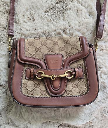 guci torba: Braon torba crossbody sa GG logom . Nosi se preko ramena, ima 2 tačke — 1