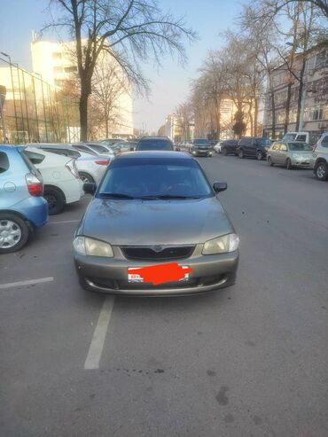 мазда вонга: Седан Mazda Familia в цвете "мокрый асфальт" (серый). Автомобиль имеет