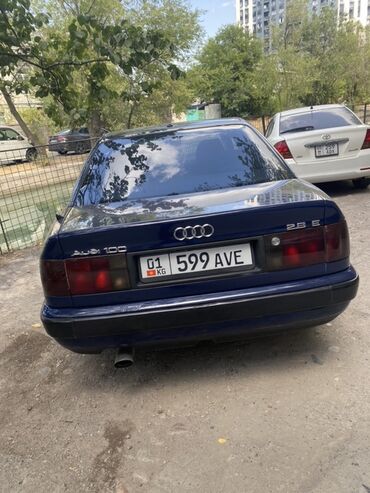 авто в рассрочку без банка без первоначального взноса в бишкеке: Седан Audi 100 синего цвета с характерным дизайном кузова. Автомобиль