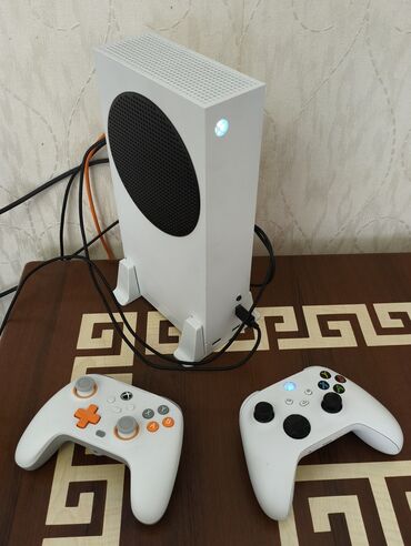 Oyun diskləri və kartricləri: Ağ rəngli Xbox Series S oyun konsolu. Konsol şaquli yerləşdirmə üçün