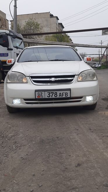 купить машину в рассрочку без банка: Белый седан Chevrolet Lacetti, оснащенный фарами дневного света и