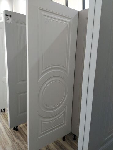 ev ucun qapi: Ağ rəngdə, klassik dizaynlı qapı. Qapının səthi müxtəlif bəzək