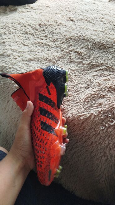 железные шипы на бутсах: Футбольные бутсы Adidas Predator в оранжево-черной расцветке. Эти