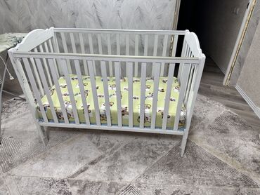 купить детскую кровать с матрасом: Детская кроватка из дерева, окрашенная в белый цвет. Имеет реечные